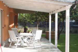 a patio with a white table and chairs on a porch at Giorgia's House in Silvi Marina