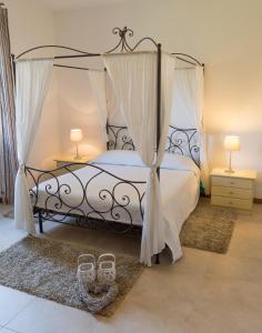 een slaapkamer met een zwart hemelbed met 2 lampen bij Le Dimore del Sole LT in Cagliari