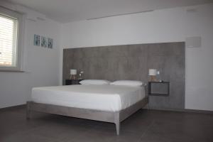 a bedroom with a large white bed with two lamps at Giorgia's House in Silvi Marina