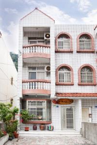 a white building with balconies on the side of it at 峽谷民宿 Valley B&B in Fushi