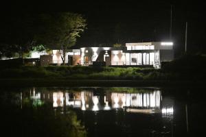 een gebouw 's nachts met een reflectie in het water bij Stay Harum Cheongdo in Hŭksŏk