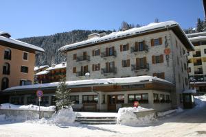 ein großes Gebäude im Schnee vor einem Berg in der Unterkunft Hotel Sport in Santa Caterina Valfurva