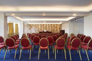 a conference room with red chairs and a podium at Nautica Bay Hotel in Porto Heli