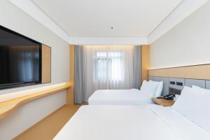 a hotel room with a bed and a tv at Ji Hotel Beijing qianmeng dian 全季北京前门地铁站酒店 in Beijing