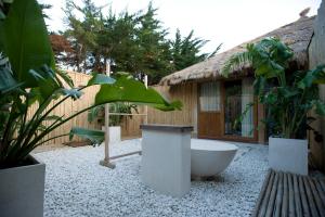 un patio con bañera y algunas plantas y un edificio en 100% Fun, en Tarifa