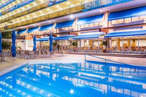 a hotel pool with chairs and blue umbrellas at Hotel Marinada in Salou