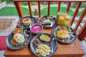 einen Tisch mit Frühstücksteller und Getränken in der Unterkunft Kapouk Cottage in Nusa Penida