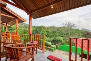 ein Balkon mit Stühlen und Blick auf einen Golfplatz in der Unterkunft Kapouk Cottage in Nusa Penida