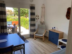 a living room with a table and a child sitting in a chair at Maisons du lac in Le Barcarès