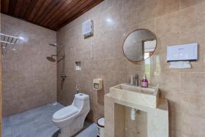 a bathroom with a toilet and a sink and a mirror at Kapouk Cottage in Nusa Penida +45 photos