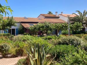 a house with a garden in front of it at Maisons du lac in Le Barcarès