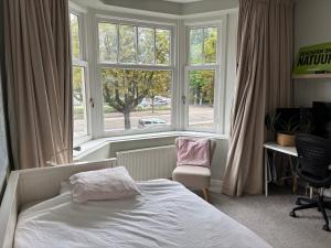 a bedroom with a bed and a window and a chair at 185m2 groot appartement met tuin in City Centre in Amsterdam