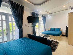 a bedroom with two beds and a couch and a tv at Queen Sea Hotel in Phan Thiet
