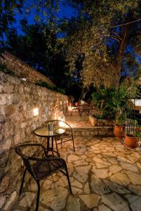 a table and chairs on a stone patio at night at Rizos Bay Sarakiniko in Sarakiniko