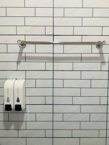 a white tiled bathroom with two rolls of toilet paper at The 10 Club Hostel & Tiny Villas in Thong Sala +87 photos