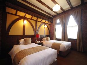 a hotel room with two beds and a window at Unzen Kanko Hotel in Unzen +116 photos