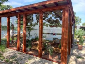 a wooden gazebo with glass doors at The Riva Sun-Suite in Šamorín +3 photos