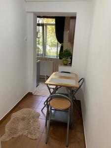 a table and chair in a small room with a rug at Lidia in Piteşti +10 photos