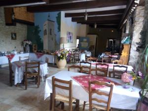 Hotel l'Oronge في سان جان دو جارد: مطعم فيه طاولات وكراسي في الغرفة