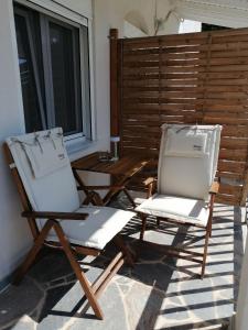 two folding chairs sitting on a patio with a window at Euphoria Estate 2 in Agia Marina Aegina