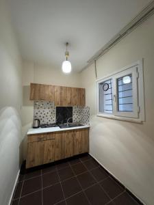 una cocina con fregadero y ventana en Stanpoli Family Apartments, en Estambul