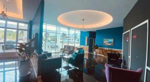 a lobby with blue walls and chairs and a chandelier at Stirling Suites Hotel & Serviced Apartment in Miri