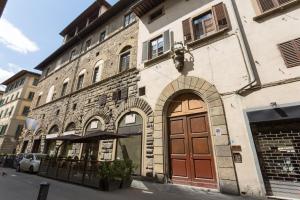 フィレンツェにあるレジデンツァ デポカ ヒストリア ラグジュアリー ブティックの茶色の扉のある建物