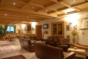 a living room with leather furniture and a dining room at Hotel Sport in Santa Caterina Valfurva