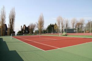 a tennis court with two tennis courts at Hotel Bellevue in Villerville