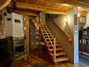 a wooden staircase in a living room with a fireplace at Gospodarstwo Agroturystyczne MALWA in Tuliszków