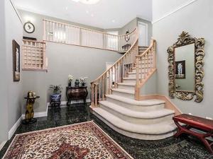 una escalera en una casa con espejo y alfombra en Maple Guesthouse, en Vancouver