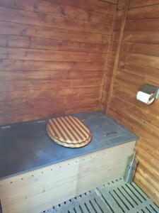 a toilet in a room with a wooden wall at Yourte traditionnelle mongole in Marcoux