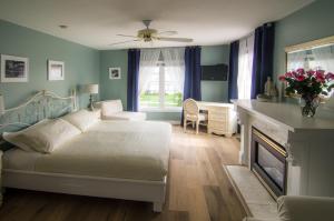 um quarto com uma cama com lareira e uma secretária em In Elegance em Niagara-on-the-Lake