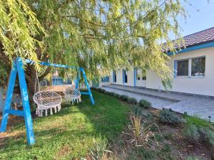 茹里洛夫卡Casa Feodor的一个带两把椅子和一棵树的秋千院