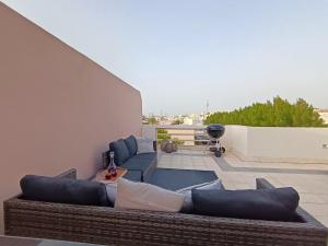 a living room with a couch and chairs on a roof at Luxury 3 Bedroom Villa MSQ Muscat Parkside Retreat in Muscat