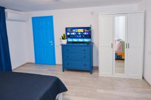 a bedroom with a blue dresser with a tv on it at Casa Feodor in Jurilovca