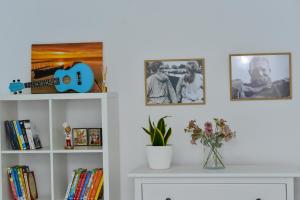a shelf with pictures and a guitar on a wall at Casa Feodor in Jurilovca +17 photos