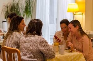 un grupo de mujeres sentadas en una mesa hablando en Hotel Bertaina en Santa Fe