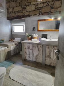 a bathroom with a sink and a toilet and a mirror at Flora's Traditional House in Malona Village +61 photos