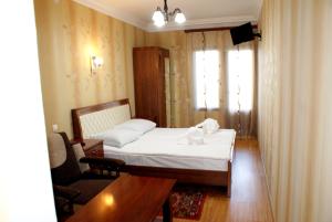 a bedroom with a bed and a chair and a table at Odzun Hotel in Alaverdi