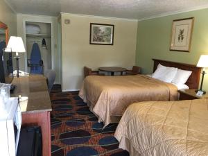 Habitación de hotel con 2 camas y mesa en colony motel Jamestown, en Jamestown