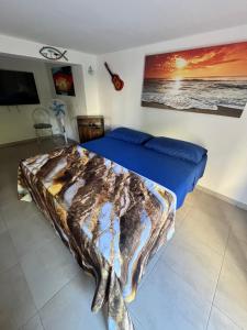 a bedroom with a bed with blue sheets and a tv at Rifugio Sul Mare in Vada