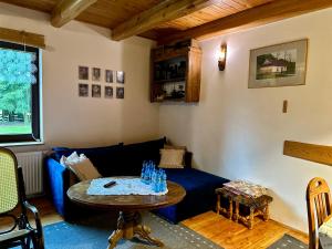 a living room with a blue couch and a table at Gospodarstwo Agroturystyczne MALWA in Tuliszków