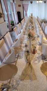 a long table with wine glasses and flowers on it at Privat Gazda Pension in Ždiar