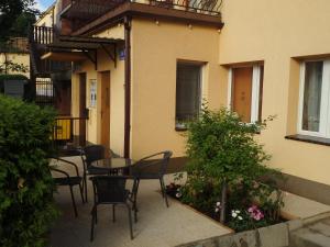 a patio with chairs and a table in front of a building at Apartament CURIE - studio in Międzyzdroje