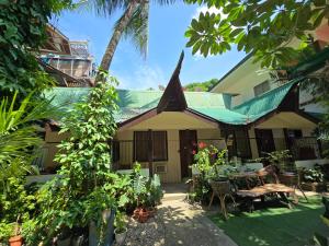 a house with a garden and a palm tree at Islandfront El Nido in El Nido