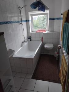 a bathroom with a tub and a toilet and a window at Gartenblick in Cremlingen