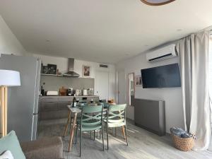 a living room with a table and chairs and a kitchen at Apartamerica 471, Gartenwohnung, Pool, 150 M zum Strand, Las Americas in Costa de Adeje