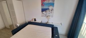 Appartement bord de mer le Capitaine في فالراس بلاج: سرير في غرفة مع صورة على الحائط