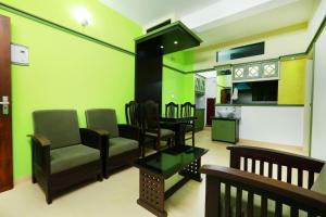 Una sala de estar con un sofá y sillas y una cocina. en SHALOM RESIDENCY, en Kakkanad 29 fotos más
